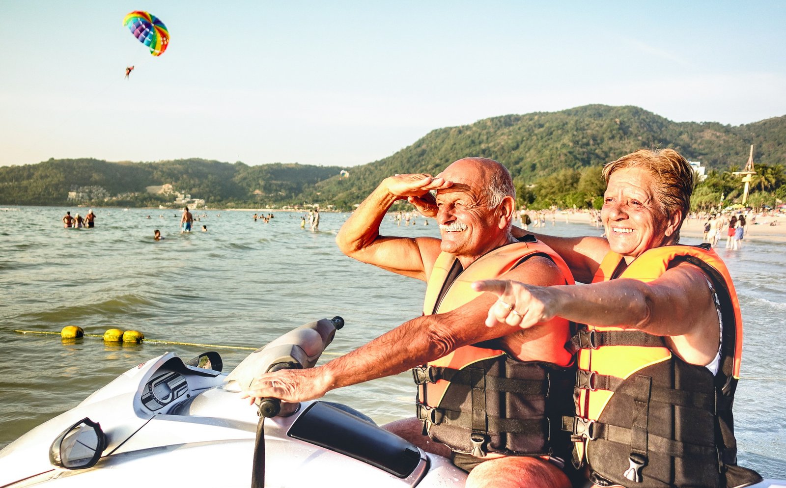 Senior happy couple having fun on jet ski at beach island hopping tour
